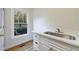Updated laundry room features a white vanity, countertop, and window with a wooded view at 2883 Thurleston Ln, Duluth, GA 30097