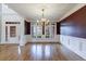 Living room featuring large windows, hardwood floors, white pillars, and recessed ceiling at 2883 Thurleston Ln, Duluth, GA 30097