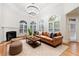 Sunlit living room with fireplace, hardwood floors, vaulted ceiling, large windows, and sectional seating at 2883 Thurleston Ln, Duluth, GA 30097