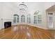 Sun-filled living room featuring hardwood floors, a fireplace, a chandelier, and large windows with plantation shutters at 2883 Thurleston Ln, Duluth, GA 30097