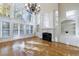 Bright living room with large windows, a fireplace, built-in shelves, and hardwood floors at 2883 Thurleston Ln, Duluth, GA 30097
