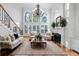 Cozy living room with fireplace, stairway, hardwood floors, large windows, and comfortable seating at 2883 Thurleston Ln, Duluth, GA 30097