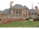 Rear exterior of a brick home with a large backyard, patio, and large windows at 2883 Thurleston Ln, Duluth, GA 30097