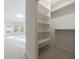 Spacious walk-in closet with built-in shelving and ample storage space next to large bonus room with many windows at 2883 Thurleston Ln, Duluth, GA 30097