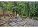 Relaxing backyard space with stone pavers, Adirondack chairs, and a fire pit at 3390 Kenland Se Rd, Smyrna, GA 30082