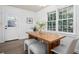 Dining area with a wooden table, modern bench seating, and a large window at 3390 Kenland Se Rd, Smyrna, GA 30082