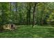 A peaceful backyard with mature trees and a storage shed at 4030 Tanglewood Rd, Snellville, GA 30039