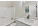 A bright bathroom features modern vanity, countertop, and tub with shower at 4030 Tanglewood Rd, Snellville, GA 30039