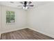 This bedroom features wood look flooring, a ceiling fan, and a window at 4030 Tanglewood Rd, Snellville, GA 30039