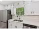Well-lit kitchen with white cabinets, stainless steel appliances, and a view of the backyard at 4030 Tanglewood Rd, Snellville, GA 30039