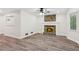 Bright living room with stone fireplace, modern ceiling fan, and beautiful wood-look floors at 4030 Tanglewood Rd, Snellville, GA 30039