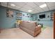 Finished basement with tan sofa and entertainment area at 6223 Emerald Springs Se Dr, Acworth, GA 30102