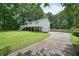 Inviting home with cracked driveway and basketball hoop surrounded by mature trees and greenery at 6223 Emerald Springs Se Dr, Acworth, GA 30102