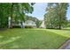View of exterior and yard surrounded by mature trees and greenery for beautiful and serene setting at 6223 Emerald Springs Se Dr, Acworth, GA 30102