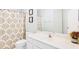 Clean bathroom includes patterned shower curtain, white vanity, and framed artwork at 380 Victorian Ln, Duluth, GA 30097