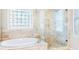 This bathroom has a standalone tub with stone finishes and glass shower at 380 Victorian Ln, Duluth, GA 30097