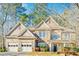 Charming two-story home with a three-car garage and stone detailing on the exterior at 380 Victorian Ln, Duluth, GA 30097