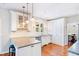 Bright kitchen with white cabinets, granite counters, modern lighting and hardwood floors at 380 Victorian Ln, Duluth, GA 30097