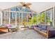 Bright sunroom with large windows, ceiling fan, stone floors and comfortable seating for relaxing at 380 Victorian Ln, Duluth, GA 30097