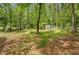 Large backyard with scattered trees and a shed, offering privacy and potential for various outdoor activities at 425 Shelby Ln, Hiram, GA 30141