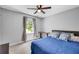 Cozy bedroom features a ceiling fan, large window, and comfortable bed with decorative pillows at 425 Shelby Ln, Hiram, GA 30141