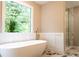 Bright bathroom featuring a freestanding tub, marble floors and a glass enclosed shower at 45 Driskell Ave, Mableton, GA 30126