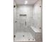 Contemporary shower with glass door, white subway tile, gold accents, and built-in bench at 45 Driskell Ave, Mableton, GA 30126