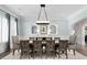 Spacious dining room with light blue walls, trim accents, large windows, and a modern candle-style light fixture at 4559 Paradise Shoals Se Rd, Atlanta, GA 30339