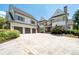 View of the home's white facade, grey shutters, stone accents, and three-car garage with an extra large driveway at 4559 Paradise Shoals Se Rd, Atlanta, GA 30339
