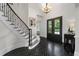 Lovely foyer with hardwood floors, tall ceilings, staircase with iron spindles, and a black framed, glass paneled entry door at 4559 Paradise Shoals Se Rd, Atlanta, GA 30339