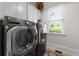 Modern laundry room with front loading washer and dryer and a view out to a green lawn at 4559 Paradise Shoals Se Rd, Atlanta, GA 30339
