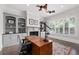 Cozy home office with custom built-in shelving, a fireplace, and a large window with wooden shutters at 4559 Paradise Shoals Se Rd, Atlanta, GA 30339
