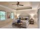 Bright main bedroom features a tray ceiling, neutral paint, a ceiling fan, and large windows at 4810 Lismoor Trce, Mableton, GA 30126