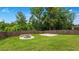 Well-maintained backyard featuring a round fire pit and grassy lawn surrounded by a stained wooden fence at 5381 Front Runner Ct, Sugar Hill, GA 30518