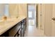 Bathroom with dark wood cabinets, a marble countertop, and a view to the bedroom at 5381 Front Runner Ct, Sugar Hill, GA 30518