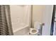 Cozy bathroom featuring a toilet, bathtub with shower, and white and gray striped shower curtain at 5381 Front Runner Ct, Sugar Hill, GA 30518