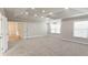 Large bedroom with tray ceilings, neutral carpet, and natural light from multiple windows at 5381 Front Runner Ct, Sugar Hill, GA 30518