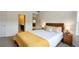 Bright bedroom featuring a wood bed frame, yellow accents, and a bedside table with lamps at 5381 Front Runner Ct, Sugar Hill, GA 30518