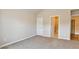Large, carpeted bedroom with neutral walls, a closet, and an open doorway to the rest of the home at 5381 Front Runner Ct, Sugar Hill, GA 30518