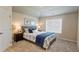 Bright bedroom featuring a large window and a bed with blue accents and bedside tables with lamps at 5381 Front Runner Ct, Sugar Hill, GA 30518