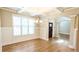 Bright, airy dining room featuring hardwood floors, modern chandelier and arched doorway at 5381 Front Runner Ct, Sugar Hill, GA 30518
