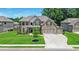 Charming two-story brick home with a three-car garage, manicured lawn, and beautiful landscaping at 5381 Front Runner Ct, Sugar Hill, GA 30518