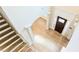 High angle of light-colored wooden stairs that meet an entryway with light wood floors at 5381 Front Runner Ct, Sugar Hill, GA 30518