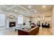 Open concept living room with fireplace, coffered ceiling, and seamless access to the kitchen at 5381 Front Runner Ct, Sugar Hill, GA 30518