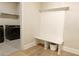 Mudroom with built-in bench and coat rack, plus laundry machines in the background at 5381 Front Runner Ct, Sugar Hill, GA 30518