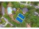 Aerial view of community amenities including a sparkling pool and tennis courts, surrounded by mature trees at 10865 Glenhurst Pass, Duluth, GA 30097