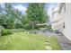 Spacious backyard with a lush lawn, a patio seating area, and beautifully planted garden beds at 10865 Glenhurst Pass, Duluth, GA 30097