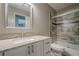 Bathroom featuring a granite countertop, a white vanity and a tiled shower and tub at 10865 Glenhurst Pass, Duluth, GA 30097
