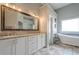 Bright bathroom featuring a tub, tile flooring and a double vanity at 10865 Glenhurst Pass, Duluth, GA 30097