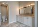 Bathroom with double vanity, large mirror with decorative lighting, and tile flooring at 10865 Glenhurst Pass, Duluth, GA 30097
